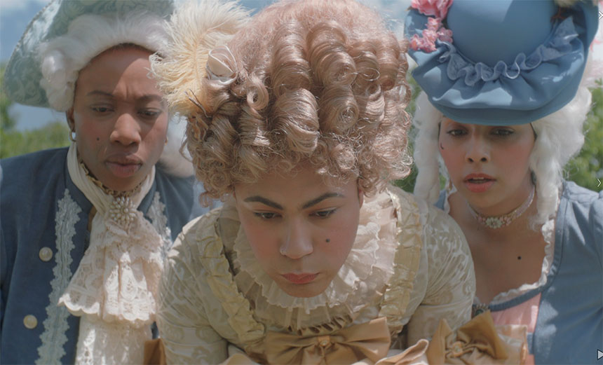 People in period costumes gather to look at something.