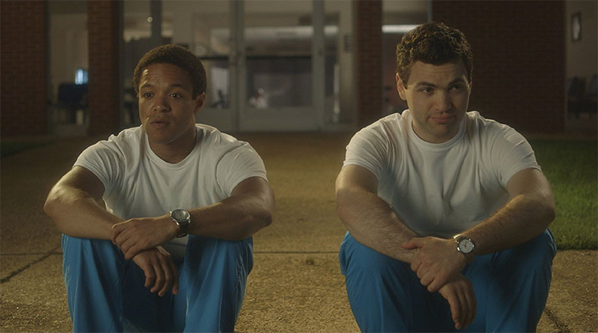 A pair of men in uniform sit on a curb.