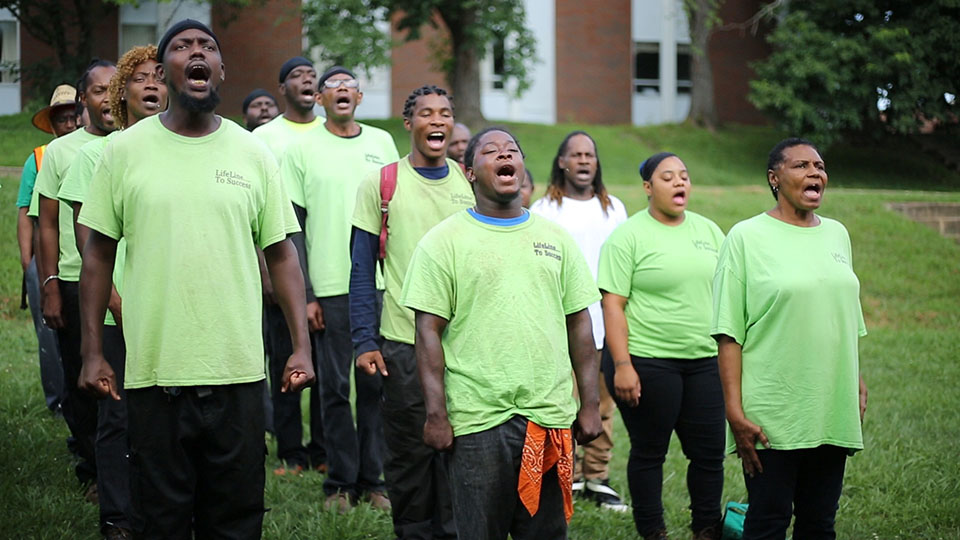A group of peopel gather together in song.